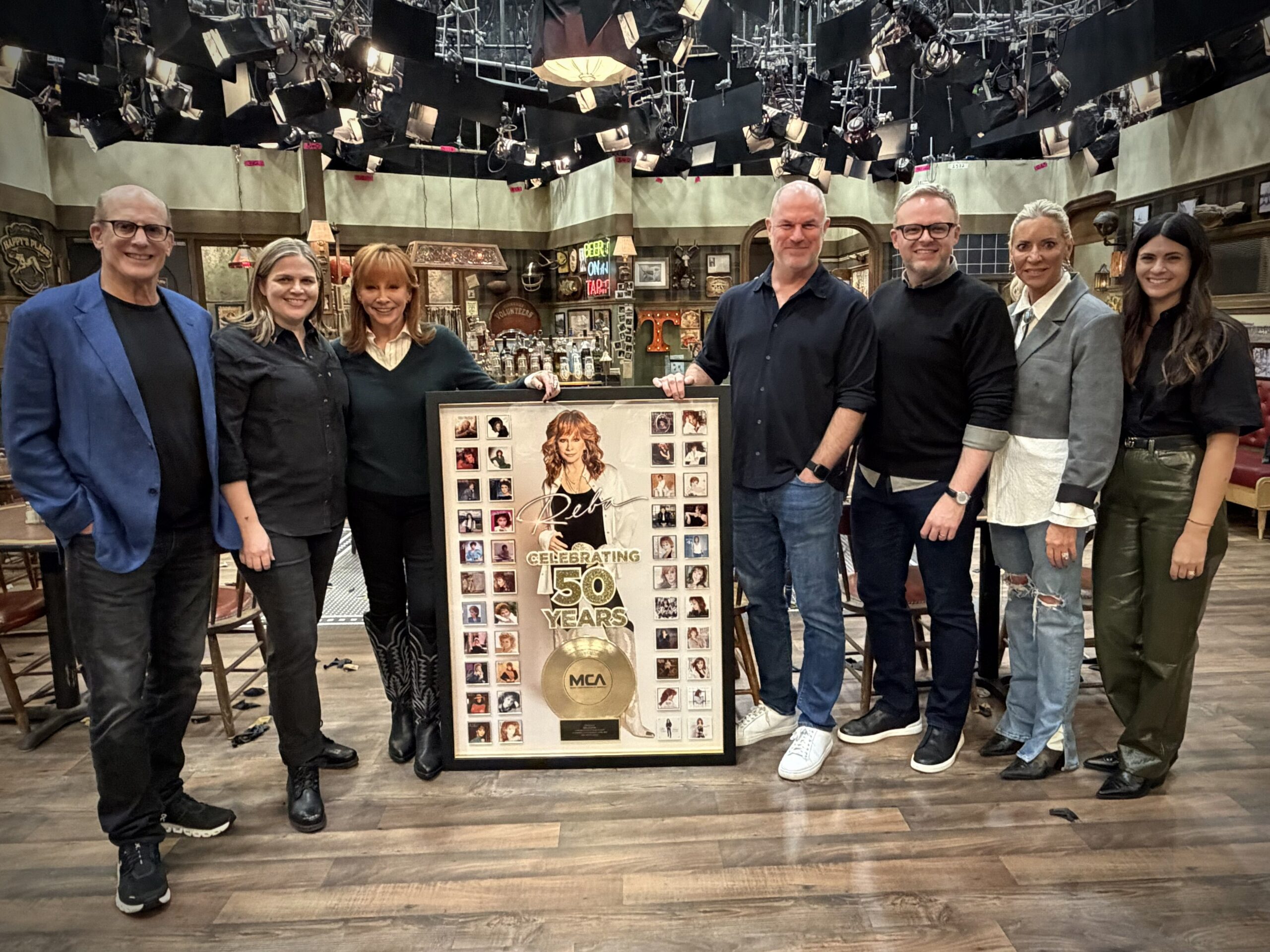 REBA MCENTIRE SURPRISED ON SET OF “HAPPY’S PLACE” TO MARK THE 50TH ANNIVERSARY OF FIRST RECORD DEAL